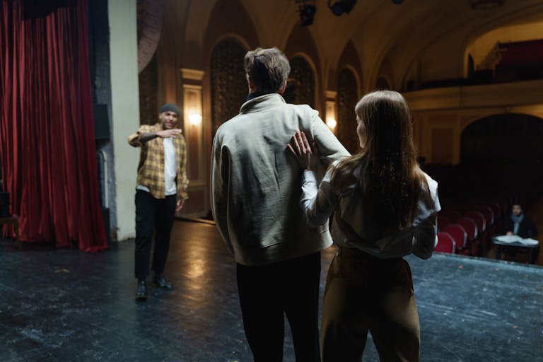 Actors in rehearsal on stage, capturing the art and emotion of theater.